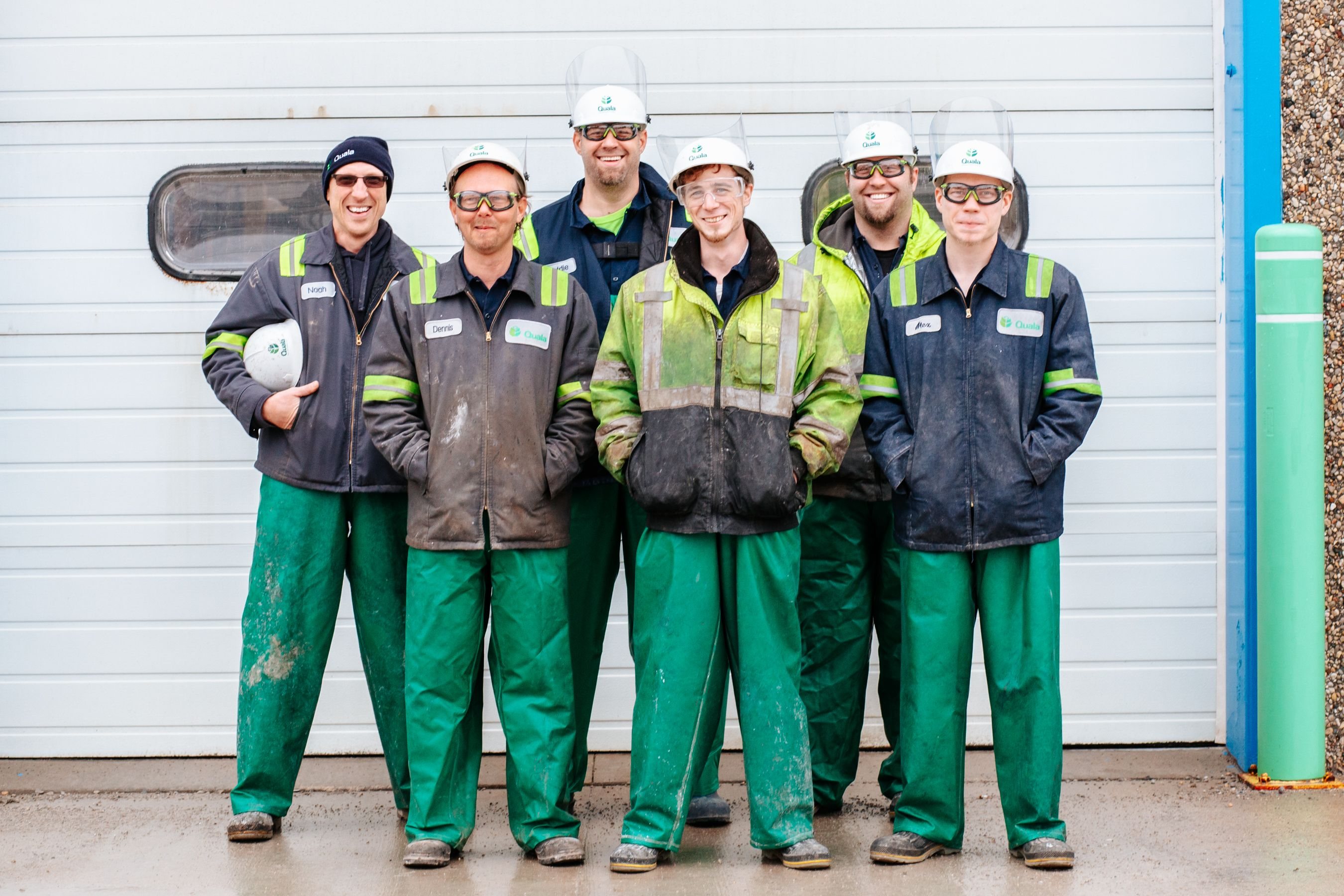 Equipo de seis operarios con cascos blancos y ropa de trabajo