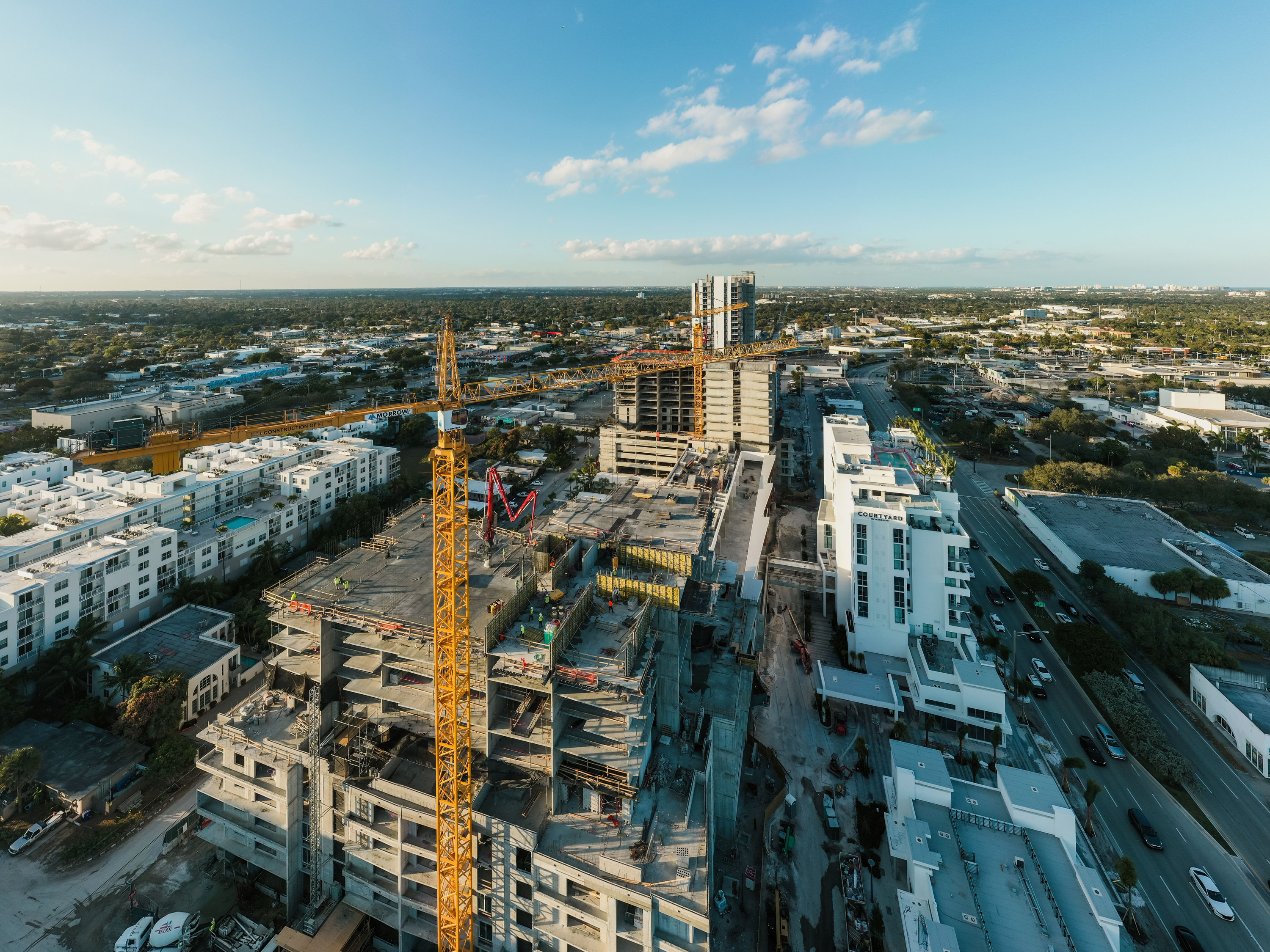 Vista aérea de una obra con grúa torre amarilla y un edificio en construcción